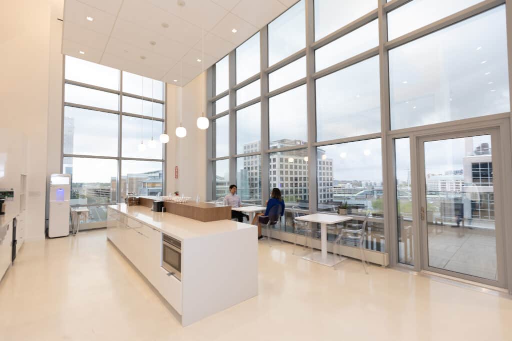 LGRA office kitchen and lounge area with large windows overlooking city skyline